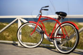 Royalty Free Photo of a Red Bike Leaning Against a Railing 