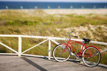 Royalty Free Photo of a Bicycle Leaning Against a Rail on Bald Head Island, North Carolina