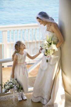 Royalty Free Photo of a Bride Holding Hands with a Flower Girl