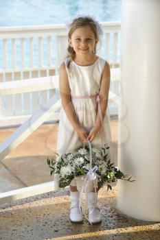 Royalty Free Photo of a Flower Girl Holding a Flower Basket and Smiling