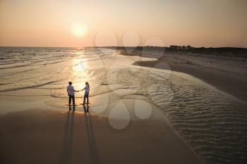 Royalty Free Photo of an Aerial Shot of a Couple Holding Hands and Walking on a Beach on Bald Head Island, North Carolina