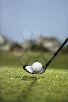 Royalty Free Photo of a Golf Ball on a Tee With a Golf Club Behind the Ball