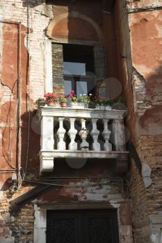 Royalty Free Photo of a Worn Building With a Balcony and Flowers in Venice, Italy