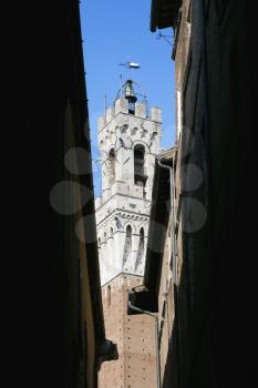 Royalty Free Photo of Torre del Mangia Bell Tower Seen Through a Darkened Alleyway