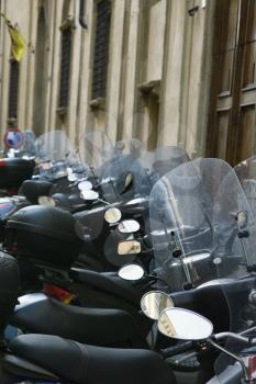 Royalty Free Photo of a Row of Motorcycles Beside a Building in Italy