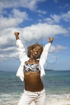 Royalty Free Photo of a Woman Stretching Arms with Ocean in the Background