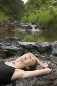Royalty Free Photo of a Woman Laying in a Freshwater Stream Laughing