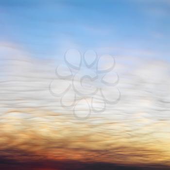 Royalty Free Photo of Wispy Clouds in Sunset Colored Sky