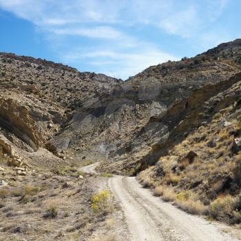 Royalty Free Photo of a Dirt Road Winding Through Rocky Desert Cliffs of Cottonwood Canyon, Utah