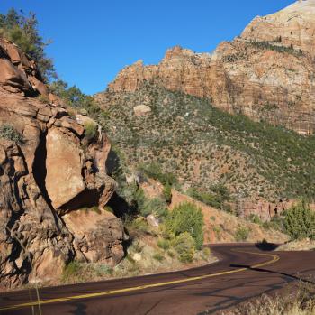 Royalty Free Photo of Two Lane Road Winding Through Rocky Desert Cliffs in Zion National Park, Utah
