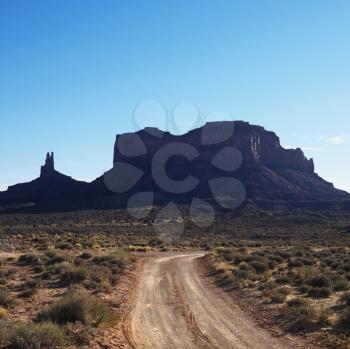 Royalty Free Photo of a Road Headed Toward Rock Formations in the Desert of Monument Valley, Utah