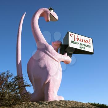 Royalty Free Photo of a Pink Dinosaur Holding a Sign for the City of Vernal, Utah
