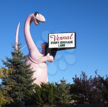 Royalty Free Photo of a Pink Dinosaur Golding a Sign for the City of Vernal, Utah