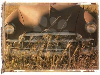 Royalty Free Photo of a Polaroid Transfer of the Front End of an Old Abandoned Antique Car in a Field