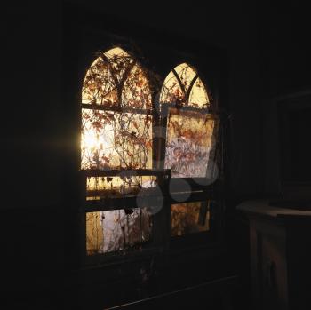 Royalty Free Photo of Sunlight Glowing Through Dilapidated Arched Windows