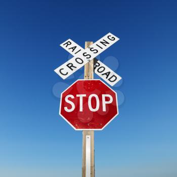 Royalty Free Photo of a Railroad Crossing and Stop Signs