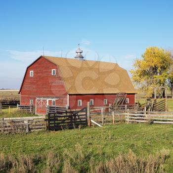 Royalty Free Photo of a Red Barn and Fence in Field