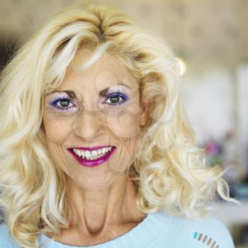 Royalty Free Photo of a Tan Blonde Woman Wearing Lots of Makeup and Smiling
