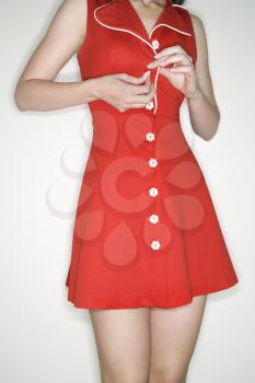 Royalty Free Photo of a Woman Buttoning a Retro Dress