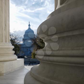 Royalty Free Photo of the Capitol Building From Behind the Columns of the Supreme Court Building in Washington DC