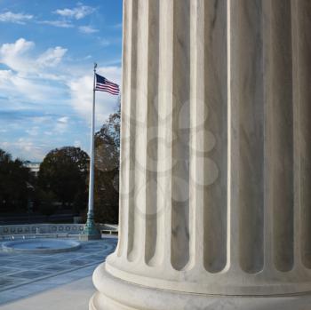Royalty Free Photo of a Column of Supreme Court Building With American Flag in Washington DC, USA