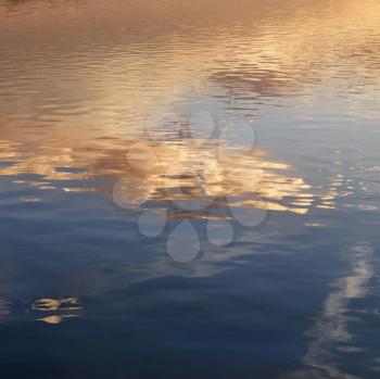 Royalty Free Photo of Reflections of Orange and Yellow Sunset on Rippling Water