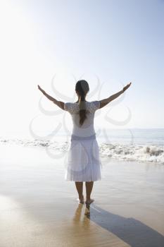 Royalty Free Photo of a Woman Holding Her Arms Up on the Beach