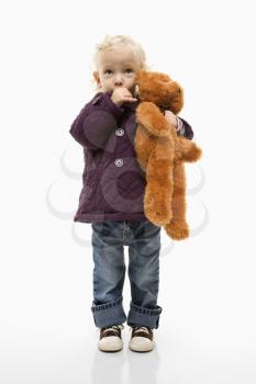 Royalty Free Photo of a Toddler Sucking Her Thumb and Holding Her Teddy Bear
