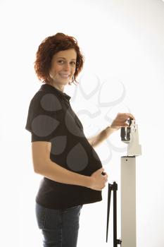 Royalty Free Photo of a Pregnant Woman Standing on a Scale