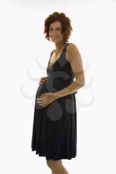 Royalty Free Photo of a Pregnant Woman With Hands on Her Belly and Smiling