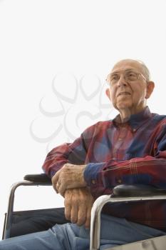Portrait of Caucasion elderly man sitting in wheelchair with hands clasped.