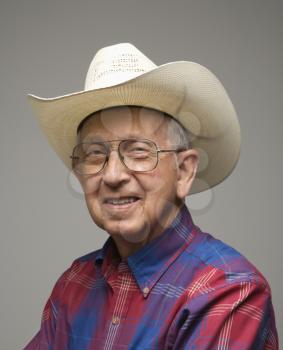 Royalty Free Photo of a Smiling Elderly Man Wearing a Plaid Shirt and Cowboy Hat