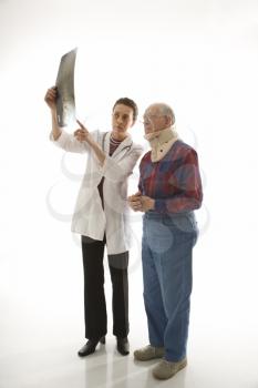 Royalty Free Photo of a Doctor Showing an X-Ray to an Elderly Man in a Neck Brace