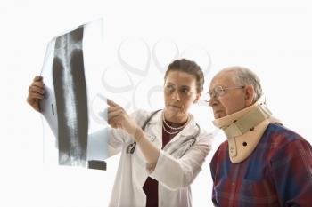 Royalty Free Photo of a Doctor Showing an X-Ray to an Elderly Man in a Neck Brace