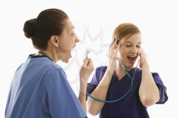 Royalty Free Photo of Health Care Workers Wearing Scrubs While Yelling into a Stethoscope