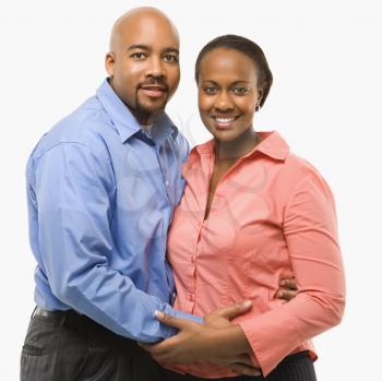 Portrait of African American couple with arms around eachother against white background.