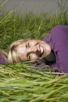 Royalty Free Photo of a Woman Lying in Grass Laughing