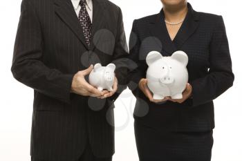 Royalty Free Photo of a Businessman and Businesswoman Holding Different Sized Piggybanks