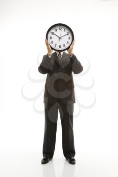 Royalty Free Photo of a Man Wearing a Suit and Holding a Clock in Front of His Face