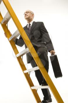 Royalty Free Photo of a Businessman Climbing a Ladder Carrying a Briefcase