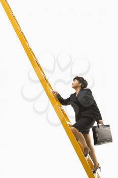 Royalty Free Photo of a Filipino Middle-aged Businesswoman Climbing a Ladder Carrying a Briefcase