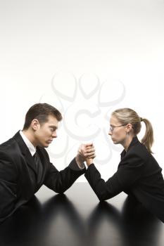 Royalty Free Photo of a Businessman and Businesswoman Arm Wrestling on a Table