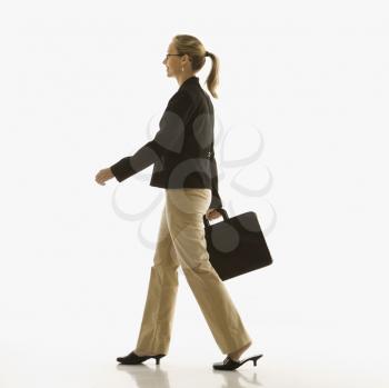 Royalty Free Photo of a Businesswoman Walking and Carrying a Briefcase