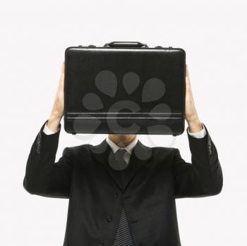 Royalty Free Photo of a Man Wearing a Suit and Holding a Briefcase in Front of His Face