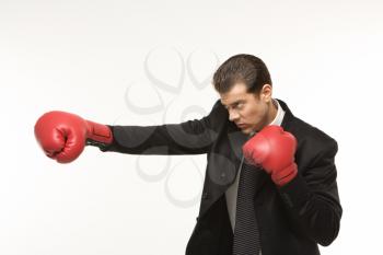 Royalty Free Photo of a Man Wearing a Suit and Punching with Boxing Gloves