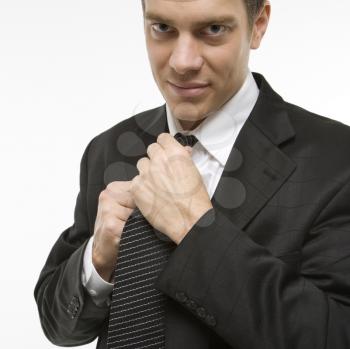 Royalty Free Photo of a Man Straightening a Necktie