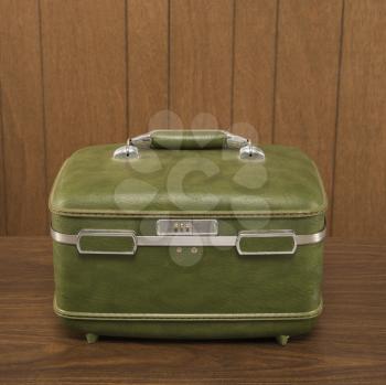 Royalty Free Photo of a Vintage Green Luggage Piece on a Wooden Desk