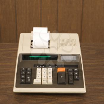Royalty Free Photo of a Vintage Adding Machine Sitting on a Wooden Desk