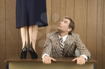 Royalty Free Photo of a Man Holding a Desk and Looking Up to a Woman Standing on the Desk