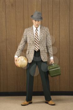 Royalty Free Photo of a Man Holding a Globe and Carrying Luggage